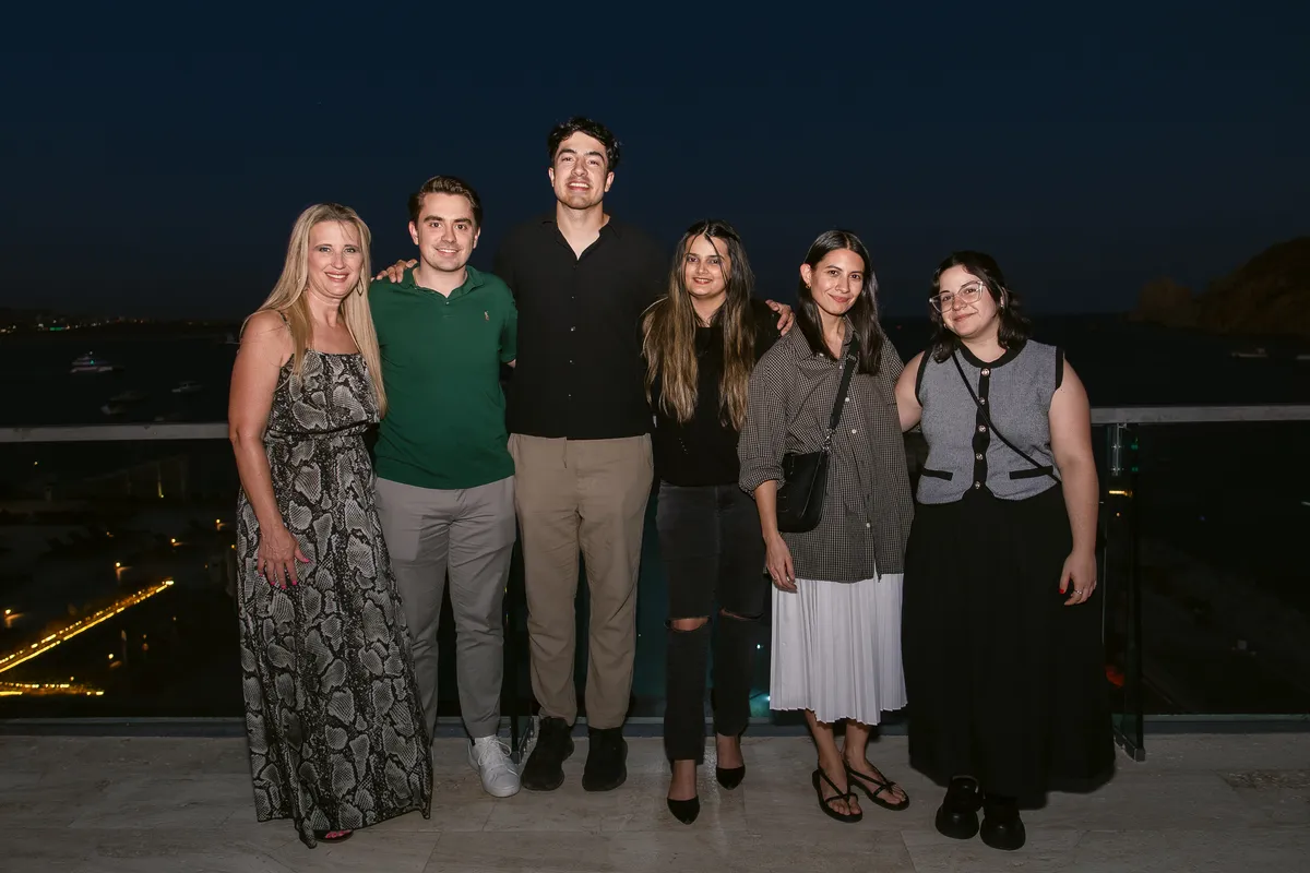 The Handl Health team together on a rooftop at dusk overlooking the coast